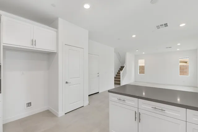 a view of a kitchen with white cabinets