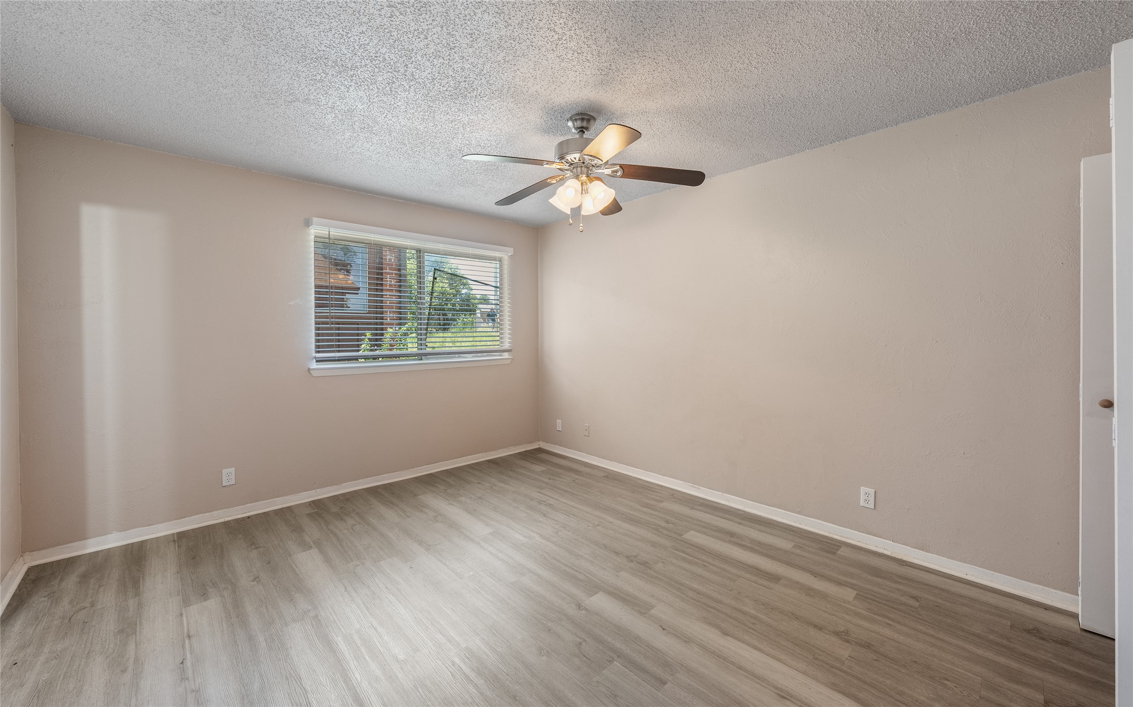 1111 West Rundberg Lane Austin, TX 78758 - Photo 10 of 16 Comfortable living space featuring wide-plank flooring and a window with blinds overlooking the surroundings.