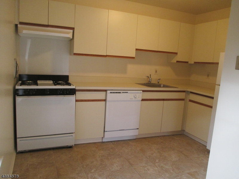 181 Long Hill Road, Unit 6 Little Falls, NJ 07424 - Photo 7 of 20 a kitchen with white cabinets and white appliances