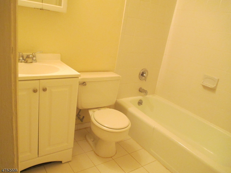 181 Long Hill Road, Unit 6 Little Falls, NJ 07424 - Photo 9 of 20 a bathroom with a granite countertop toilet and a sink