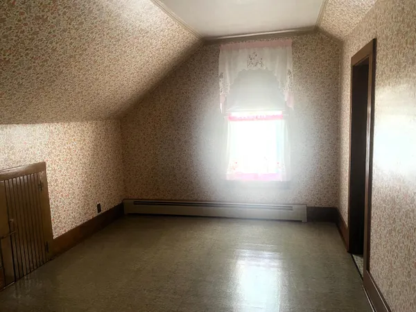 a view of a small space with wooden floor and a window
