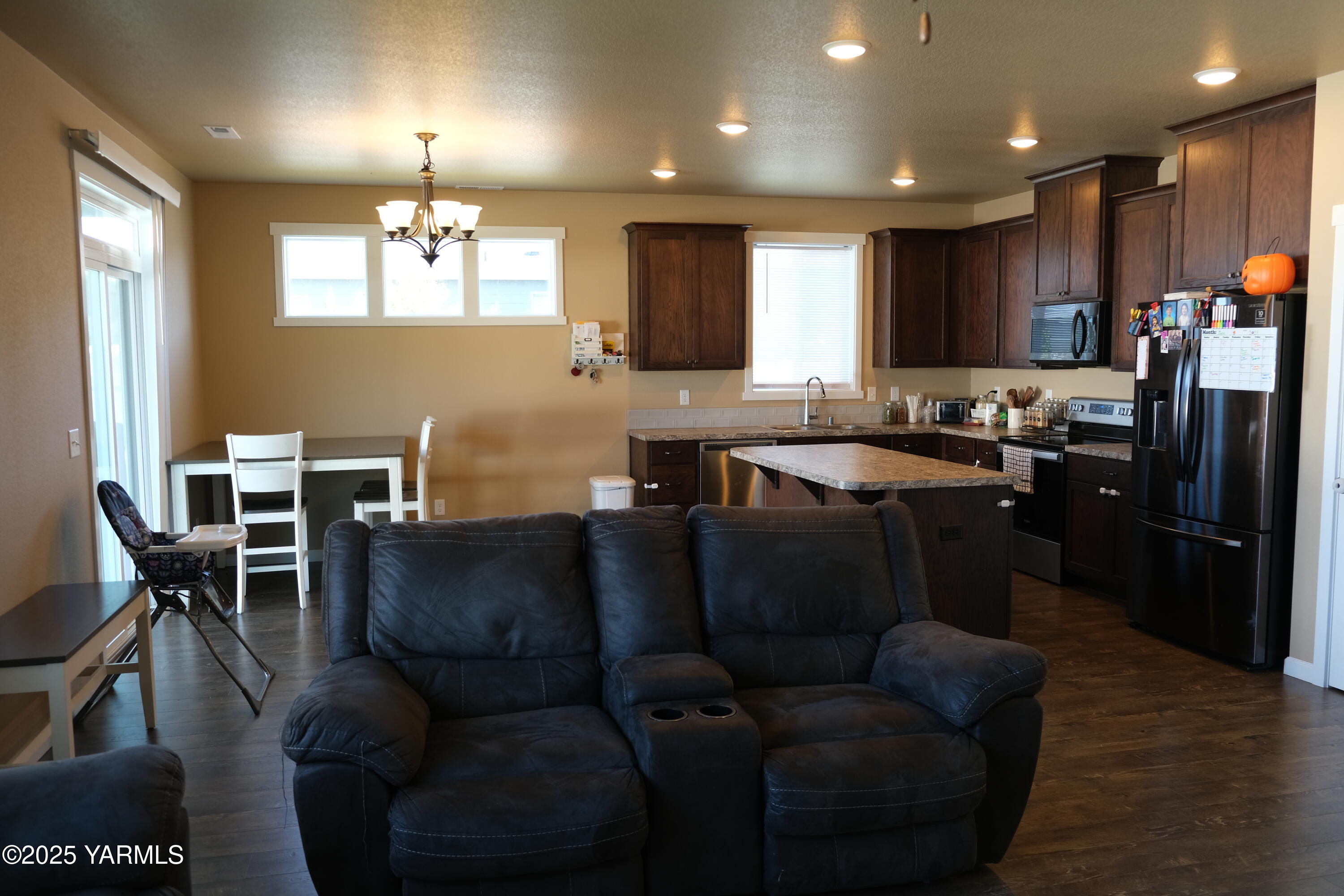 2206 Porter Loop Yakima, WA 98901 - Photo 7 of 34 a living room with stainless steel appliances kitchen island granite countertop furniture a refrigerator a sink a dining table and chairs