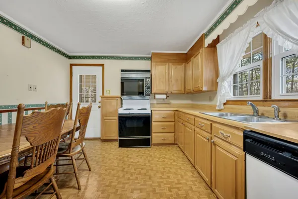 a kitchen with granite countertop a sink counter top space appliances and cabinets