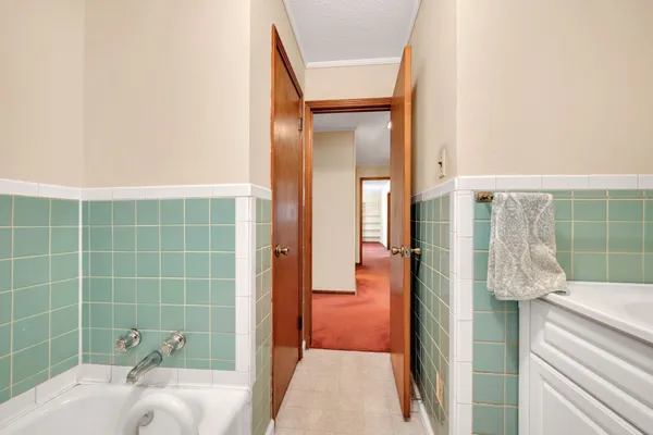 a bathroom with a tub shower and sink