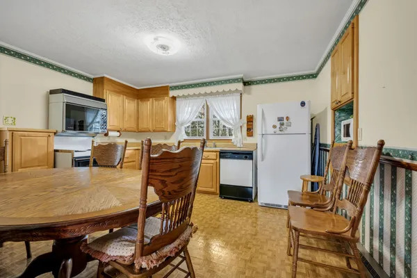 a kitchen with a table chairs refrigerator and microwave