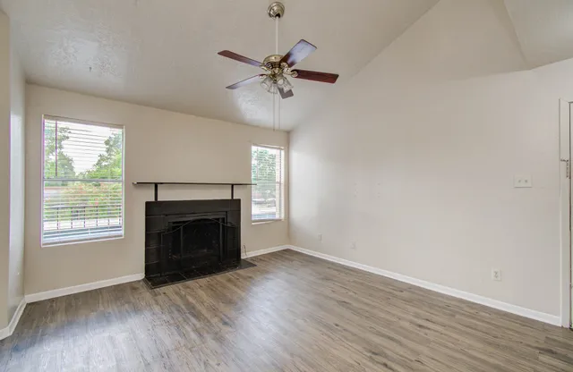 an empty room with windows fireplace and a sink