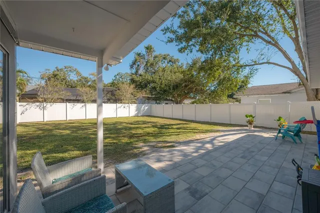 a view of a large pool with lawn chairs under an umbrella