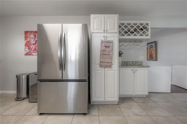 a kitchen with white cabinets and refrigerator