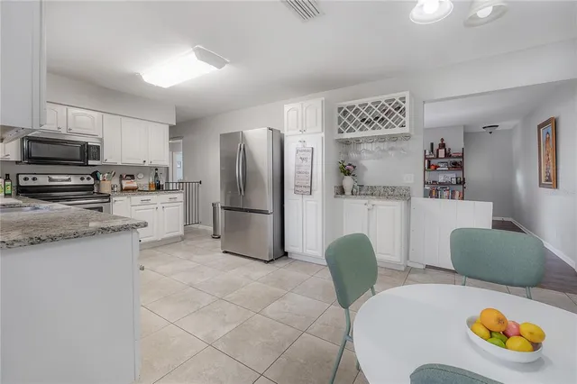 a kitchen with stainless steel appliances granite countertop a refrigerator and a stove top oven