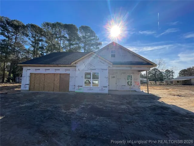 a front view of house with yard and trees in the background