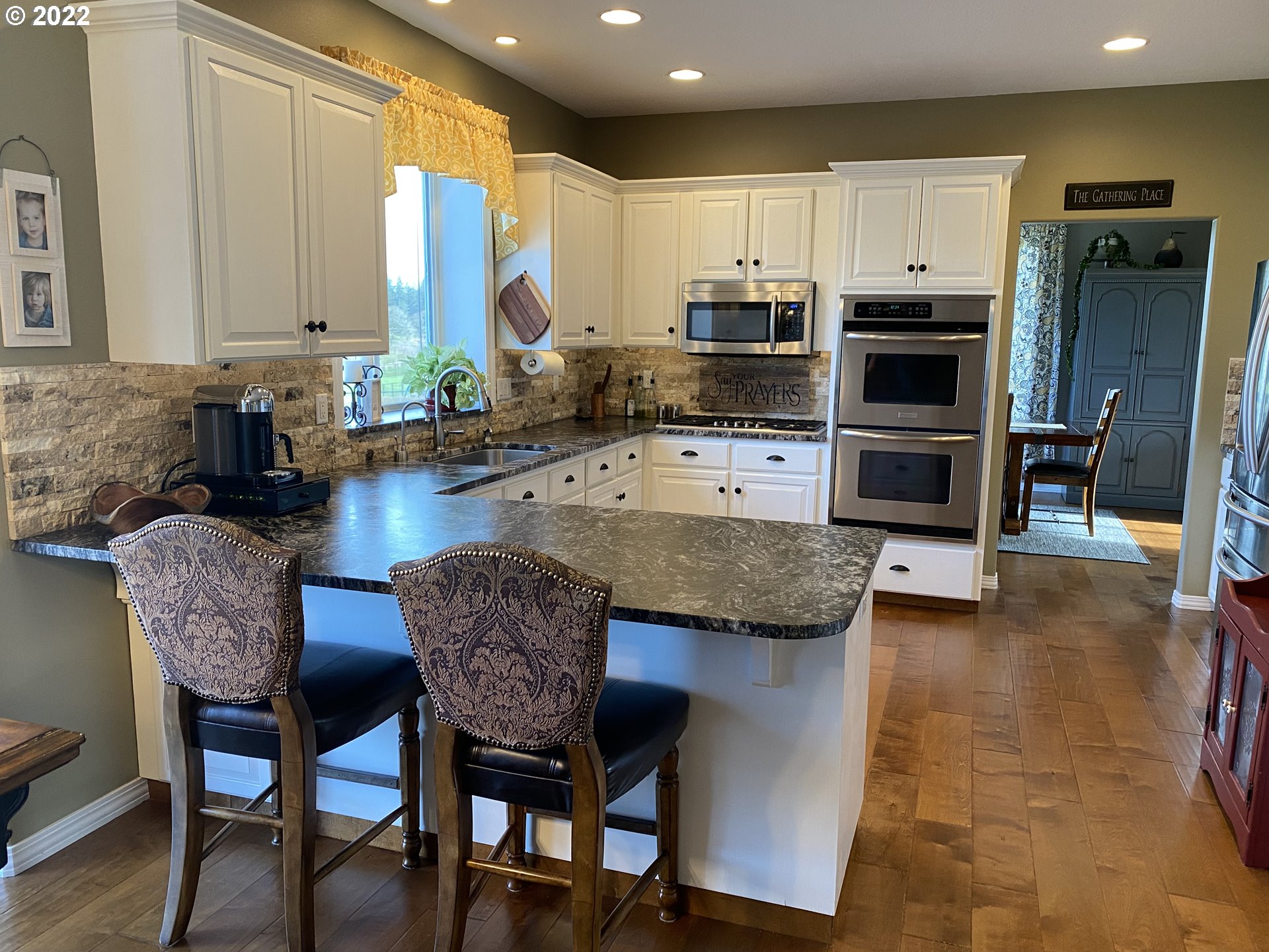 5606 Northwest 280th Street Ridgefield, WA 98642 - Photo 6 of 32 a kitchen with stainless steel appliances granite countertop a table chairs sink refrigerator and microwave