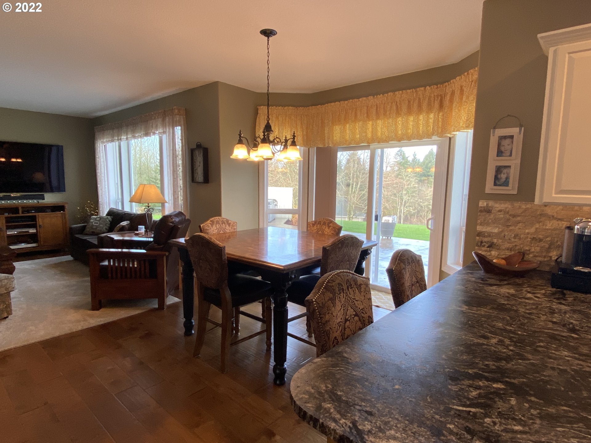 5606 Northwest 280th Street Ridgefield, WA 98642 - Photo 8 of 32 a living room with couches a flat tv screen and a dining table with garden view