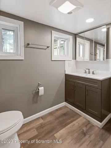 a bathroom with a sink a toilet and a window