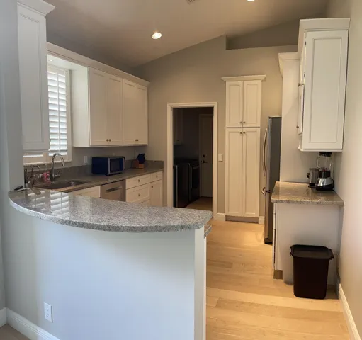 a kitchen with stainless steel appliances granite countertop a sink a stove and a refrigerator