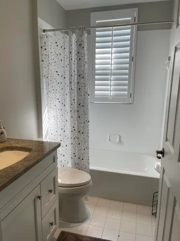 a bathroom with a granite countertop toilet a sink and a bathtub