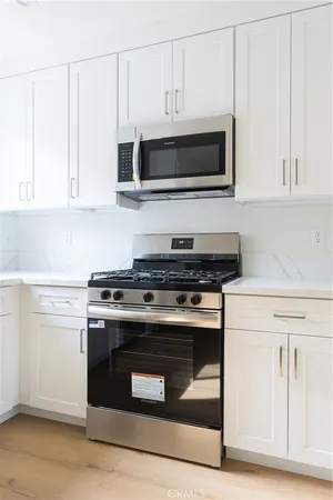 a kitchen with stainless steel appliances granite countertop a stove and a microwave