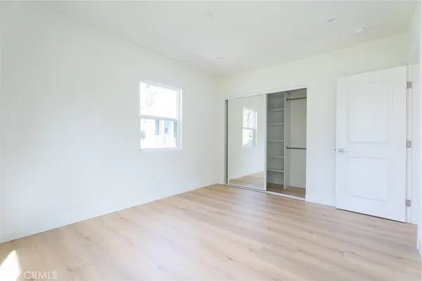 an empty room with wooden floor and window