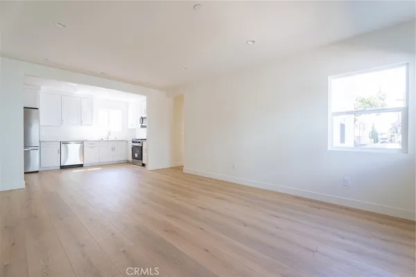 a view of empty room with wooden floor and windows