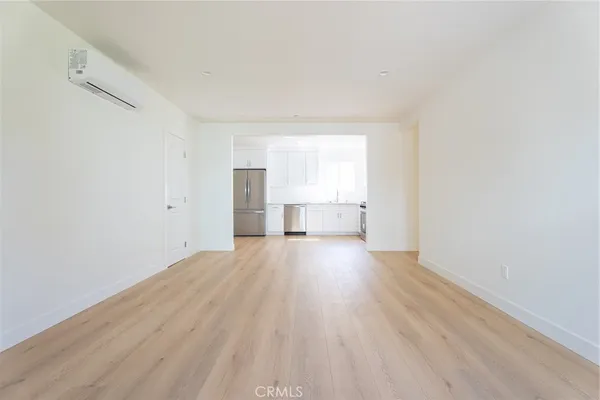 a view of empty room with wooden floor and window