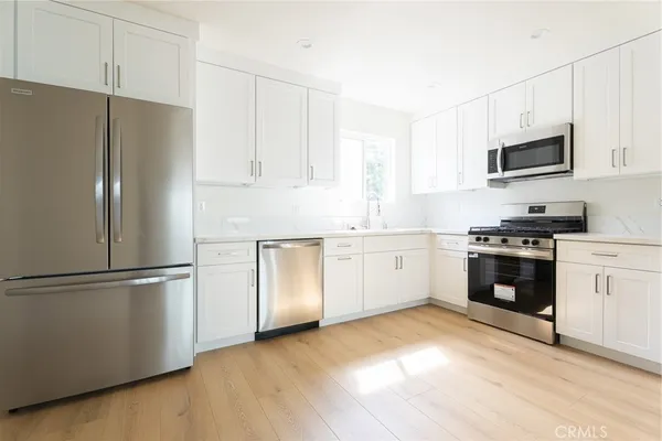 a kitchen with stainless steel appliances white cabinets and a refrigerator
