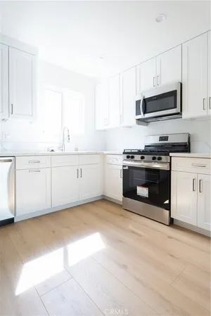 a kitchen with stainless steel appliances granite countertop a stove a sink and a microwave