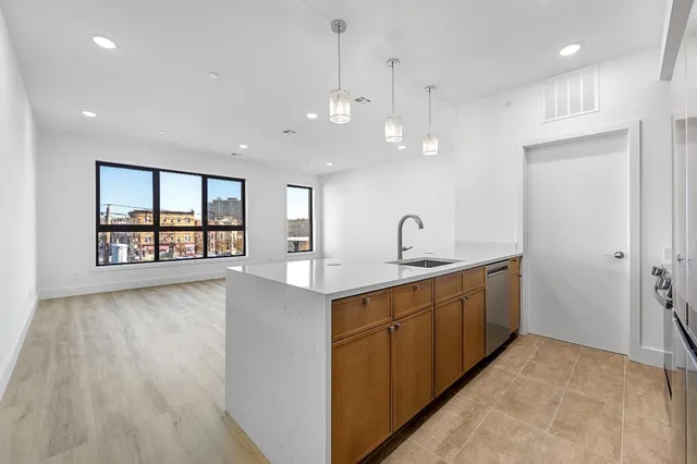 a view of a big room with wooden floor and windows