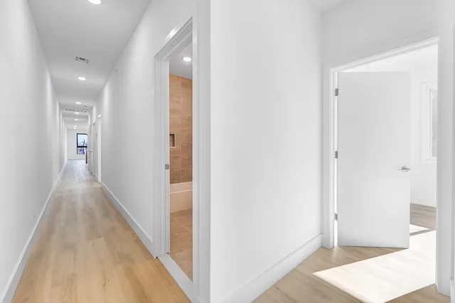 a view of a hallway with wooden floor