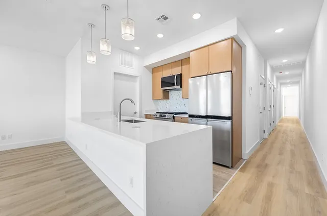 a view of a kitchen with a sink and wooden floor