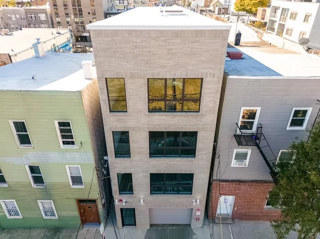 a aerial view of a brick building next to a yard