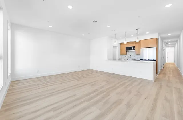 a view of a kitchen with a sink and a refrigerator