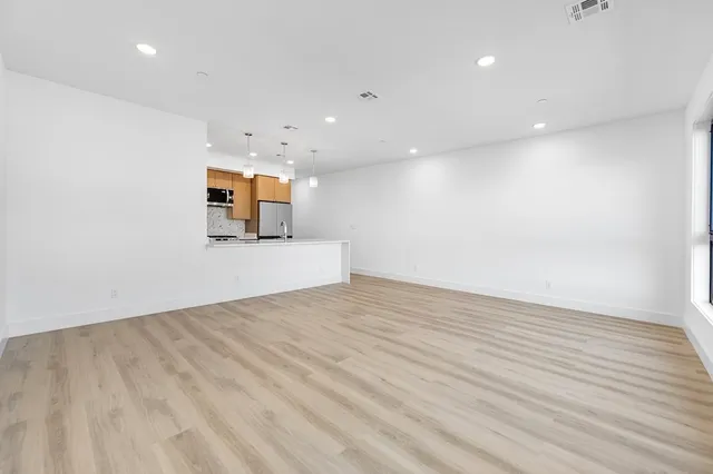 a view of empty room with wooden floor