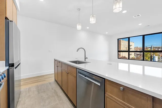 a kitchen with stainless steel appliances a sink and a large window
