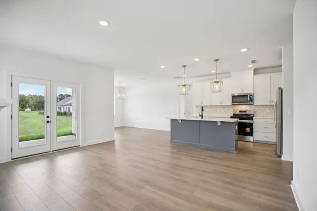 a view of kitchen with kitchen island stainless steel appliances refrigerator sink and cabinets