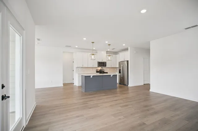 an empty room with windows and fireplace
