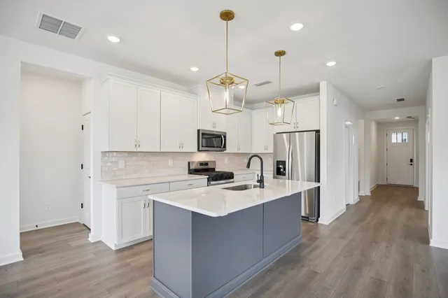 a kitchen with white cabinets and stainless steel appliances