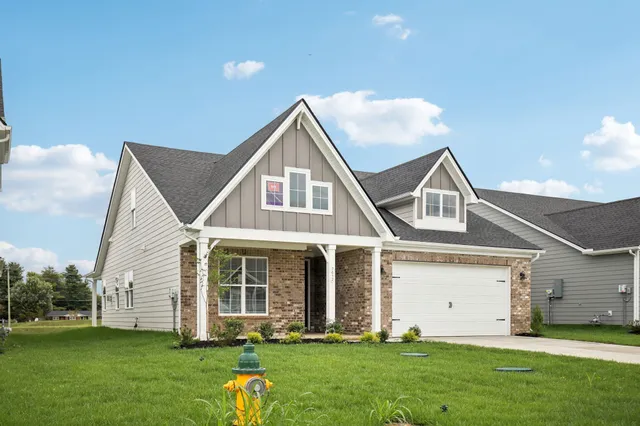 a front view of a house with a garden and yard