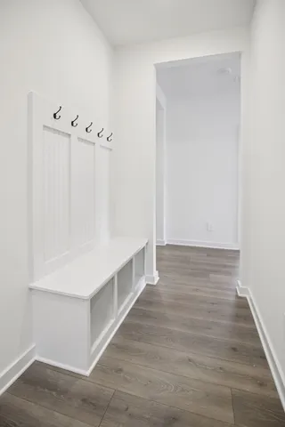 an empty room with wooden floor fireplace and windows