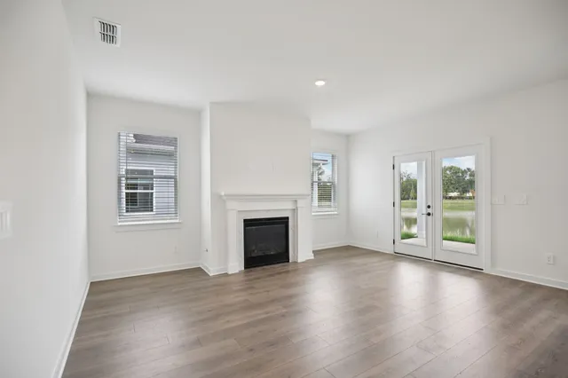 a view of empty room with wooden floor and fireplace