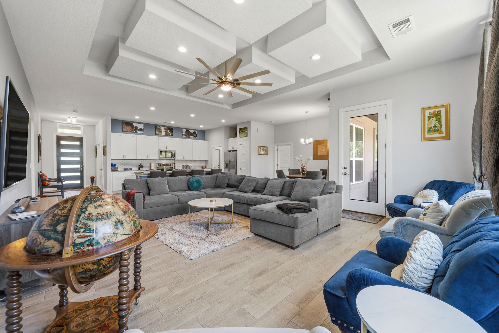 18605 Masters Cove Point Venture, TX 78645 - Photo 11 of 40 Living area featuring a multi-tiered tray ceiling, recessed lighting, and a ceiling fan