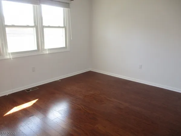 a view of a small space with wooden floor and a window