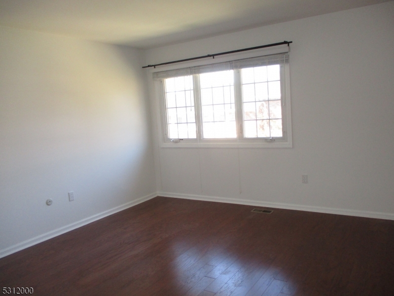777 Springfield Avenue, Unit 17 Summit, NJ 07901 - Photo 20 of 25 an empty room with wooden floor and windows