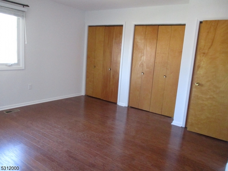 777 Springfield Avenue, Unit 17 Summit, NJ 07901 - Photo 22 of 25 an empty room with wooden floor and windows