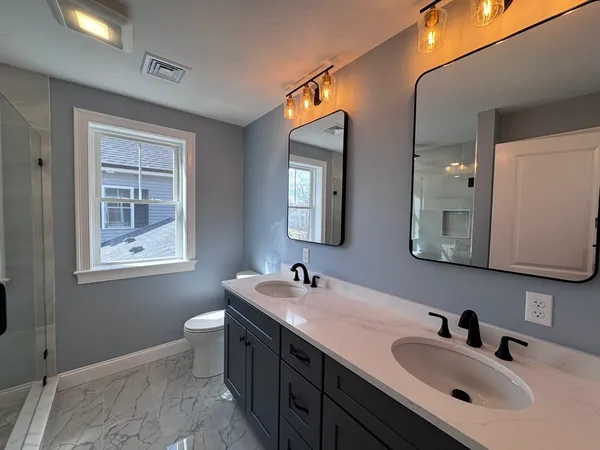 a bathroom with 2 sink and a mirror