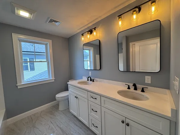 a bathroom with a toilet sink and mirror