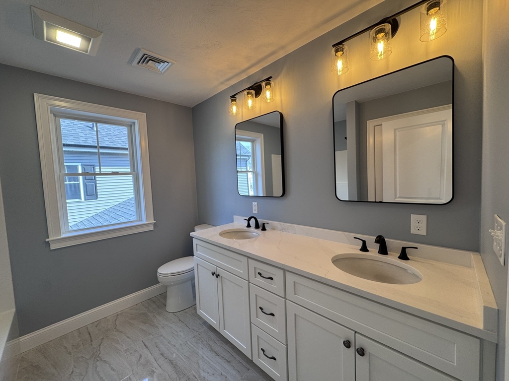 193 East Spring Street Avon, MA 02322 - Photo 16 of 27 a bathroom with a toilet sink and mirror