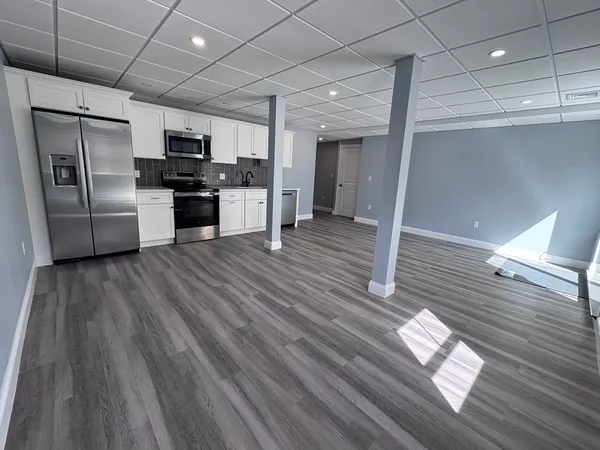 a kitchen with stainless steel appliances wooden floors and refrigerator