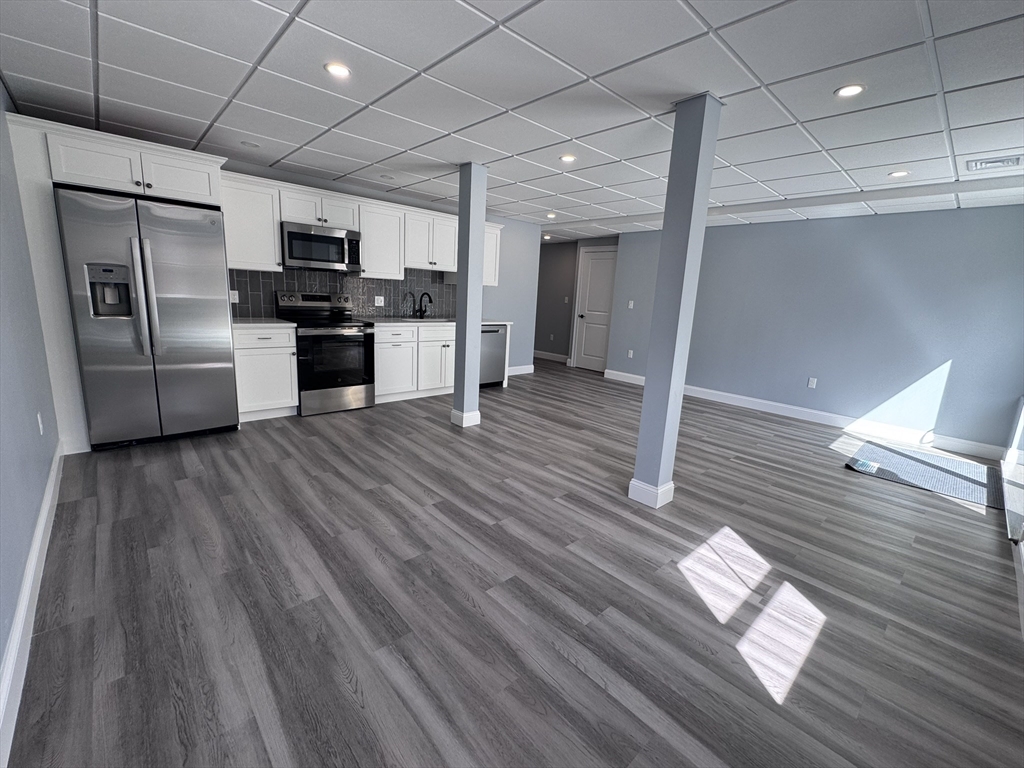 193 East Spring Street Avon, MA 02322 - Photo 21 of 27 a kitchen with stainless steel appliances wooden floors and refrigerator