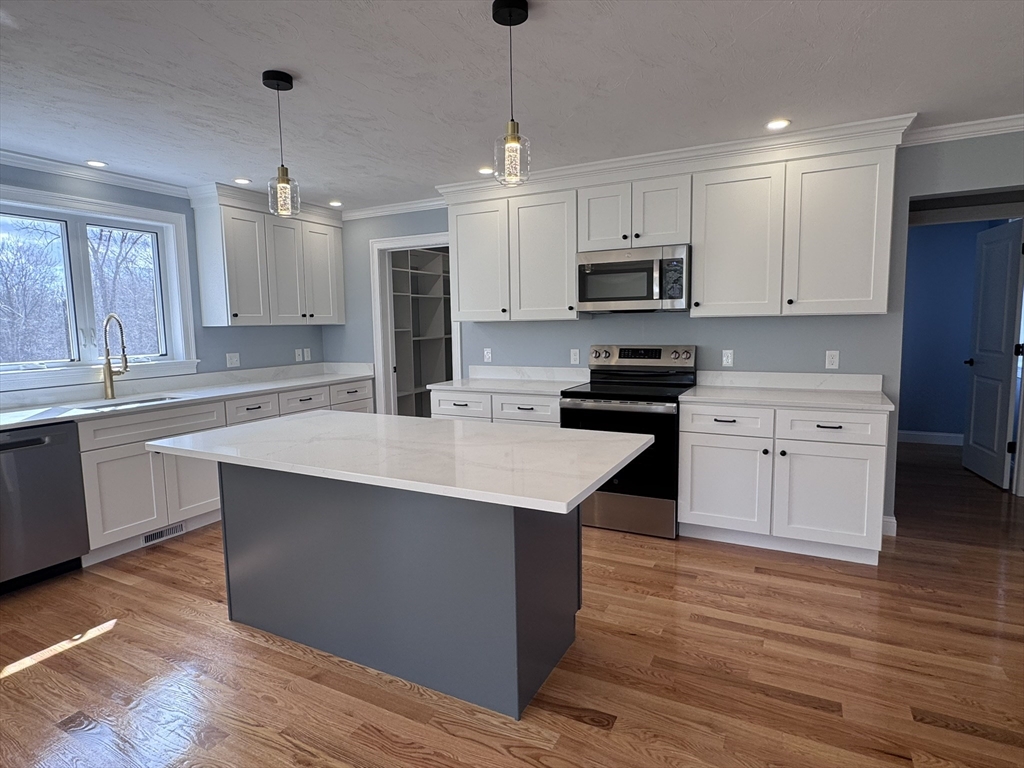 193 East Spring Street Avon, MA 02322 - Photo 4 of 27 a kitchen with stainless steel appliances granite countertop a sink stove and refrigerator