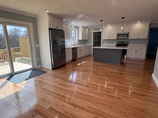 a view of kitchen with granite countertop cabinets and refrigerator