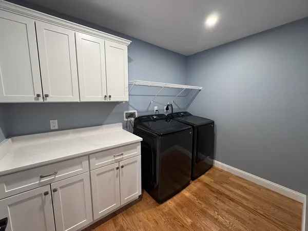 a utility room with cabinets washer and dryer